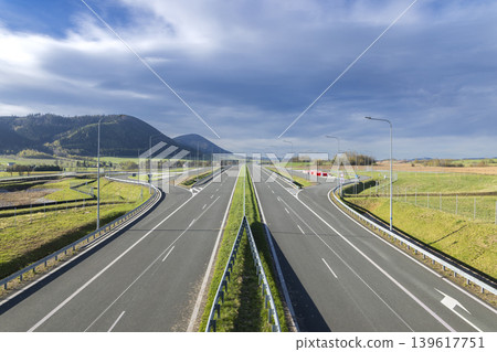 Empty highway leading into mountains and blue sky Empty highway leading into mountains and blue sky 139617751