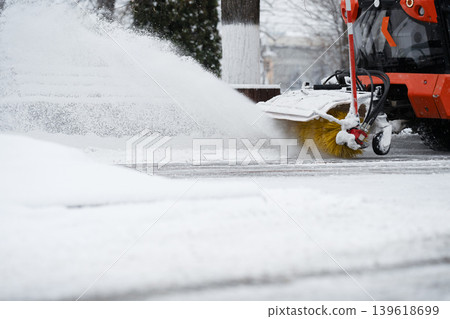 Snowblower machine with rotary brush clears snow . Heavy duty vehicle performs public maintenance Snowblower machine with rotary brush clears snow . Heavy duty vehicle performs public maintenance 139618699
