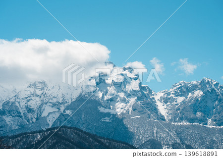 The iconic silhouette of Mount Stolovaya (Stolovaya Gora) covered in snow under a bright blue sky. This majestic limestone massif is a famous landmark near Vladikavkaz in North Ossetia-Alania, Russia. The iconic silhouette of Mount Stolovaya (Stolovaya Gora) covered in snow under a bright blue sky. This majestic limestone massif is a famous landmark near Vladikavkaz in North Ossetia-Alania, Russia. 139618891