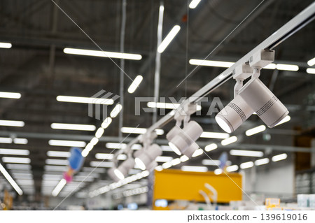 Ceiling-mounted track lighting with grey cylindrical spotlights. Ceiling-mounted track lighting with grey cylindrical spotlights. 139619016