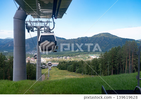 Mangekok, Russia-18.08.2024: .Cable cars over lush green landscape and forested hills in Mangerok. Mangekok, Russia-18.08.2024: .Cable cars over lush green landscape and forested hills in Mangerok. 139619628