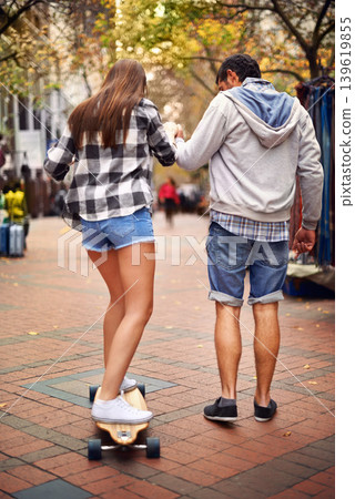 Couple, skateboarding and outdoor in city, back and excited to learn together and romantic relationship. Cape town, fun and hobby with boyfriend and girlfriend in street, helping and playful date Couple, skateboarding and outdoor in city, back and excited to learn together and romantic relationship. Cape town, fun and hobby with boyfriend and girlfriend in street, helping and playful date 139619855
