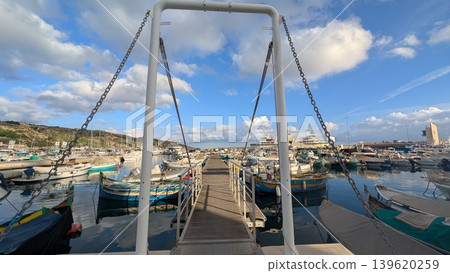 View of the long pier and the moored fishing boats around it View of the long pier and the moored fishing boats around it 139620259