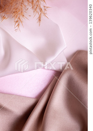 Abstract background in soft colors of silk fabrics on pink pearl paper and branch Dry beige reed. Beautiful trend texture Abstract background in soft colors of silk fabrics on pink pearl paper and branch Dry beige reed. Beautiful trend texture 139620340