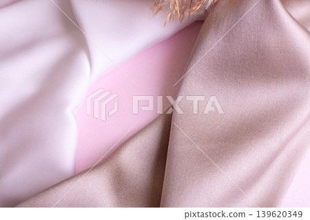 Abstract background in soft colors of silk fabrics on pink pearl paper and branch Dry beige reed. Beautiful trend texture Abstract background in soft colors of silk fabrics on pink pearl paper and branch Dry beige reed. Beautiful trend texture 139620349
