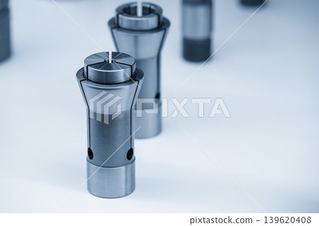 Close-up of a precision collet check for a CNC milling machine cutting tool in a blue-toned industrial scene. Close-up of a precision collet check for a CNC milling machine cutting tool in a blue-toned industrial scene. 139620408
