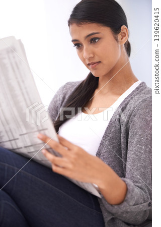 Indian woman, reading and newspaper study in a home in the morning with story, article and news. Relax, press print and calm female person with paper publication and media in house with information 139620415