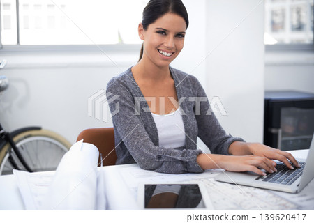 Woman, computer and floor plan in office portrait for architecture research, design planning and startup project. Young engineering worker or designer typing on laptop with blueprint and documents 139620417