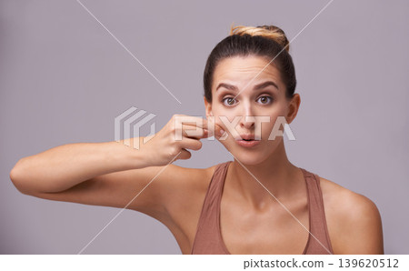 Portrait of model, squeeze cheek or skincare for wellness with acne on face, breakout or scar check. Facial dermatology, studio or confident woman with pimples or beauty results on purple background Portrait of model, squeeze cheek or skincare for wellness with acne on face, breakout or scar check. Facial dermatology, studio or confident woman with pimples or beauty results on purple background 139620512