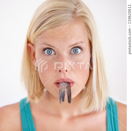 Portrait, woman and eating tail of fish with surprise and shock on white background of studio. Crazy, diet and person with taste of weird seafood, cuisine and disgust for gross or strange food Portrait, woman and eating tail of fish with surprise and shock on white background of studio. Crazy, diet and person with taste of weird seafood, cuisine and disgust for gross or strange food 139620611