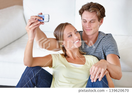 Selfie, love and couple hug in a living room for bonding, photography or memory in their home. Support, photo or people embrace in a house with phone for social media, blog or profile picture update Selfie, love and couple hug in a living room for bonding, photography or memory in their home. Support, photo or people embrace in a house with phone for social media, blog or profile picture update 139620670