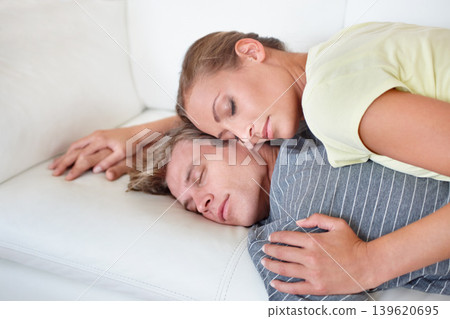 Hug, sleeping and couple relax on a sofa with love, connection or peace in their home together. Marriage, nap and people lying in living room resting, embrace and bonding in safety, trust or security Hug, sleeping and couple relax on a sofa with love, connection or peace in their home together. Marriage, nap and people lying in living room resting, embrace and bonding in safety, trust or security 139620695