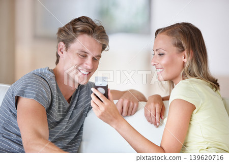 Phone, search and happy couple on a sofa checking web, planning or booking discussion at home with holiday choice. Smartphone, streaming and people in a living room with love, conversation or scroll Phone, search and happy couple on a sofa checking web, planning or booking discussion at home with holiday choice. Smartphone, streaming and people in a living room with love, conversation or scroll 139620716