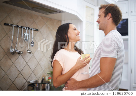 Couple, hug and wine for cooking in kitchen, healthy meal and preparing food for eating at home. Happy people, alcohol and bonding together in marriage, nutrition and embrace for support and romance 139620760