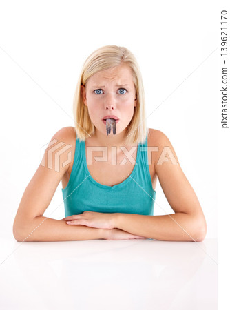 Confused, woman and portrait of eating fish, tail or strange food in mouth on white background of studio. Crazy, diet and person with weird seafood, cuisine or disgust for taste of tuna or salmon 139621170