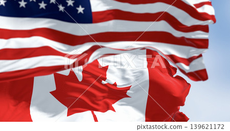 Canada and american national flags waving in the wind on a clear day 139621172