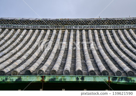The roof of nijo jo castle, Kyoto, Japan. World Heritage Site. Roof tile pattern. Major tourist attraction in Kansai region in Japan. Japan famous historic architecture. Building exterior. The roof of nijo jo castle, Kyoto, Japan. World Heritage Site. Roof tile pattern. Major tourist attraction in Kansai region in Japan. Japan famous historic architecture. Building exterior. 139621590