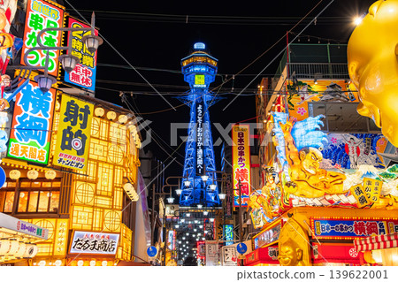 Osaka City: The flashy Shinsekai restaurant district with its rows of giant 3D billboards and the brightly shining Tsutenkaku Tower at night. 139622001