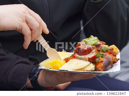Hands holding plate of roasted meat street food in Prague Hands holding plate of roasted meat street food in Prague 139622847