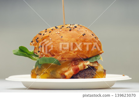 Appetizing beef burger with melted cheese and crispy bacon Appetizing beef burger with melted cheese and crispy bacon 139623070