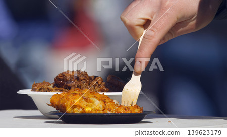 Eating savory street food with wooden fork in Karlin Eating savory street food with wooden fork in Karlin 139623179