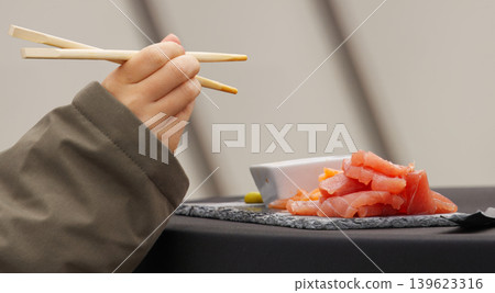 Hand with Chopsticks and Tuna at Naplavka Hand with Chopsticks and Tuna at Naplavka 139623316