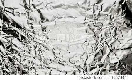 crumpled aluminum foil abstract texture reveals shiny metallic reflections with intricate crease patterns crumpled aluminum foil abstract texture reveals shiny metallic reflections with intricate crease patterns 139623441