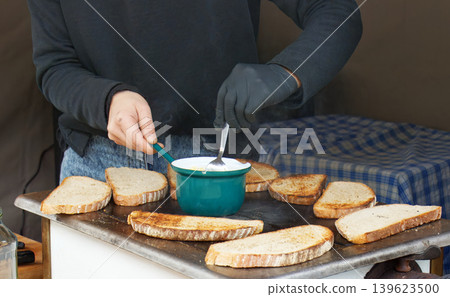 Vendor toasting bread on griddle at Naplavka farmers market. 139623500