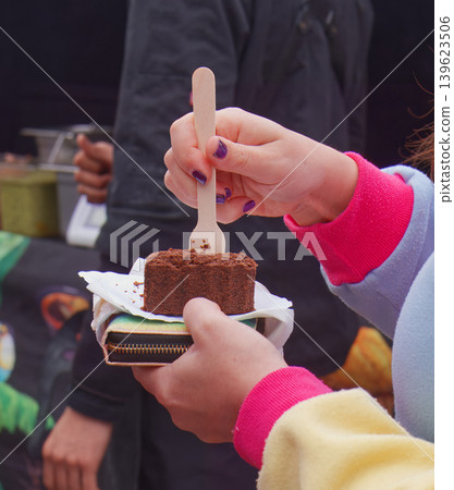 Eating chocolate brownie with wooden fork at Naplavka market Eating chocolate brownie with wooden fork at Naplavka market 139623506