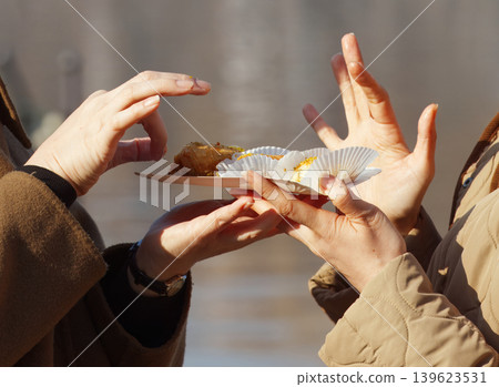 Hands Sharing Baklava Pastry at Naplavka Farmers Market 139623531