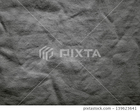 crumpled fabric texture exposes raw organic folds casting dramatic shadows in moody grayscale atmosphere 139623641