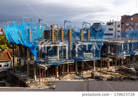Building construction site with blue safety netting Building construction site with blue safety netting 139623726