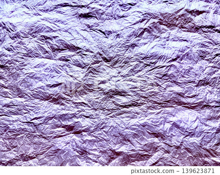 crumpled purple metallic foil shimmers revealing intricate dramatic wrinkles in abstract macro texture 139623871