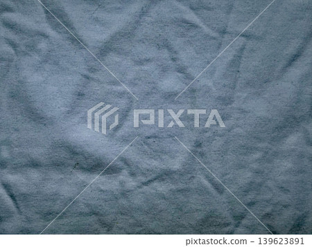 crumpled blue fabric revealing intricate wrinkles and deep textured folds in serene minimalist closeup wellness mood 139623891