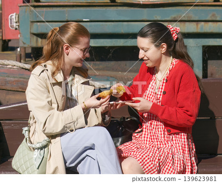 Friends enjoying sweet dessert at Naplavka farmers market Prague Friends enjoying sweet dessert at Naplavka farmers market Prague 139623981