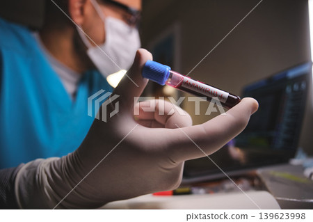 Scientist holding hantavirus positive blood test tube Scientist holding hantavirus positive blood test tube 139623998