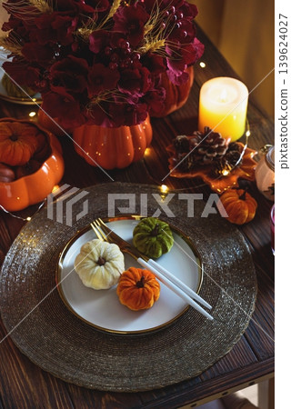 Autumnal table setting with decorative pumpkins, candles and string lights. Autumnal table setting with decorative pumpkins, candles and string lights. 139624027