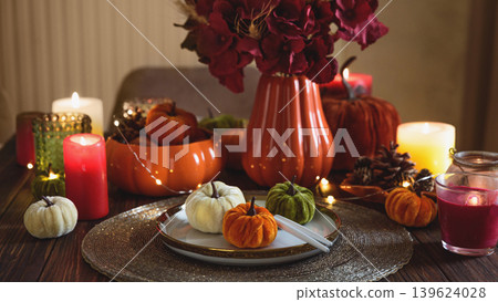 Autumnal table setting with decorative pumpkins, candles and string lights. Autumnal table setting with decorative pumpkins, candles and string lights. 139624028