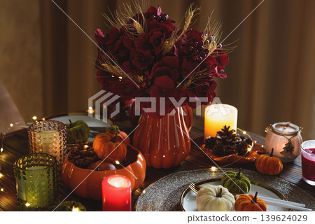 Autumnal table setting with decorative pumpkins, candles and string lights. 139624029