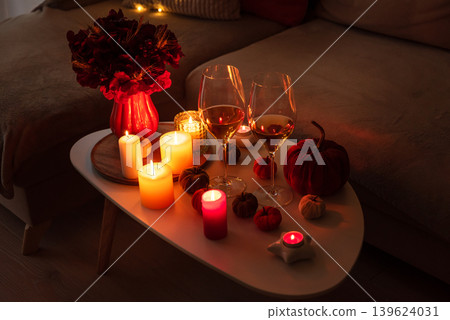 Cozy evening scene with candles, wine glasses and warm candle lighting. Cozy evening scene with candles, wine glasses and warm candle lighting. 139624031