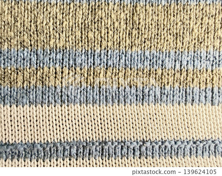 striped ribbed knit cuff texture in beige blue cream wool closeup cozy earthy sustainable fashion fabric detail 139624105