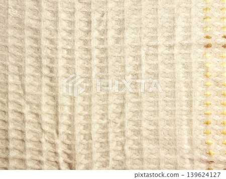 waffle weave soft cream fabric closeup revealing serene texture with intricate golden yellow honeycomb border detail waffle weave soft cream fabric closeup revealing serene texture with intricate golden yellow honeycomb border detail 139624127