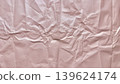 crumpled soft pink paper texture with intricate folds and delicate shadows in abstract minimalist composition 139624174