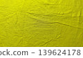 vibrant yellow crumpled linen fabric revealing natural organic wrinkles and intricate textured folds in macro detail 139624178