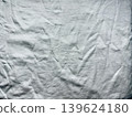 wrinkled white linen fabric closeup with dramatic folds and soft shadows in abstract minimalist monochrome texture 139624180