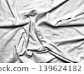 crumpled white fabric forms intricate abstract folds with dramatic shadows in soft minimalist monochrome texture 139624182