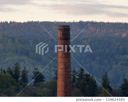 Weathered Masonry Stands Atop Mountain Ridge. Moody Dusk Sky Enhances Solitary Brick Chimney Tower Scene 139624385