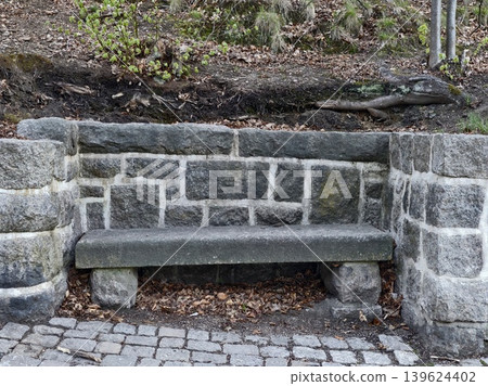 Quiet Park Scene Featuring Old Mosscovered Stone Bench Amidst Autumn Leaves And Historic Surroundings Quiet Park Scene Featuring Old Mosscovered Stone Bench Amidst Autumn Leaves And Historic Surroundings 139624402