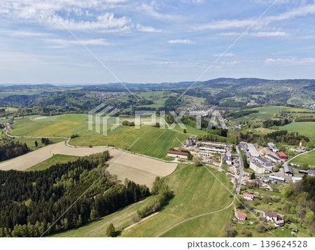 High Vantage Point Capturing Town Outskirt Merging Into Fields With Infrastructure And Mountain Ridges High Vantage Point Capturing Town Outskirt Merging Into Fields With Infrastructure And Mountain Ridges 139624528