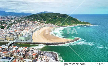 A stunning aerial view of a vibrant coastal city, its inviting beach, and rolling waves A stunning aerial view of a vibrant coastal city, its inviting beach, and rolling waves 139624753